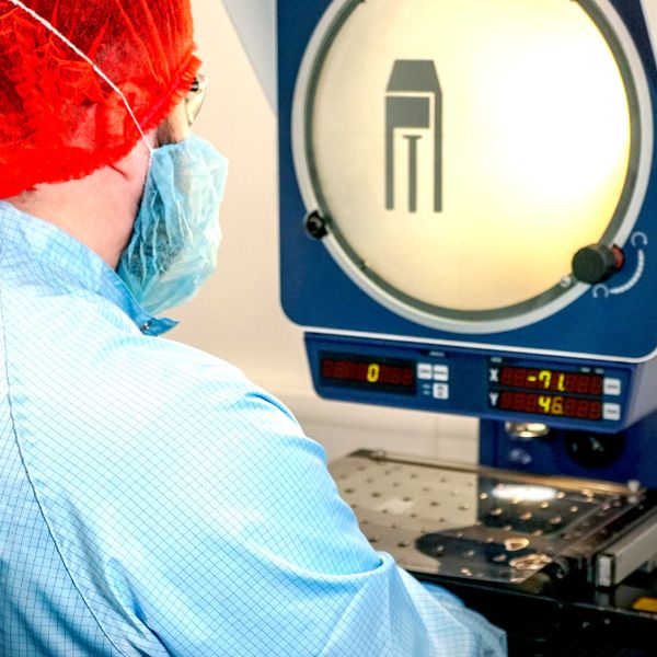 Technician using an optical comparator